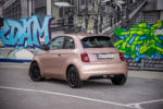 Heck des FIAT 500e in Rose Gold Metallic Lackierung, stehend vor Graffiti Wand.
